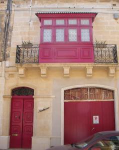 two red doors on the side of a building at Nocturne Family House in Paola
