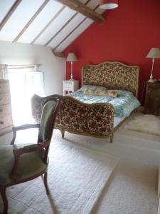 a bedroom with a bed and a chair in it at La Merlerie in Malicorne +6 photos