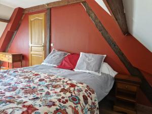 a bed in a room with a red wall at Maison Le Thuau in Sargé-lès-Le Mans