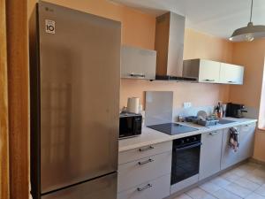 a kitchen with a large stainless steel refrigerator at Maison Le Thuau in Sargé-lès-Le Mans
