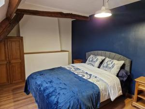 a bedroom with a bed with a blue wall at Maison Le Thuau in Sargé-lès-Le Mans +5 photos