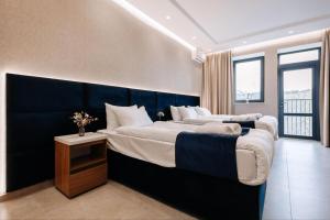 two beds in a bedroom with a blue headboard at Or Haganuz in Dobrovelychkivka