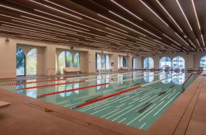 an indoor swimming pool with a large ceiling at Cortina - Yard & Wellness View in Voluntari