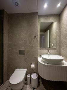 a bathroom with a sink and a toilet and a mirror at City Breeze Suites in Heraklio