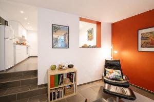 a living room with a chair and a kitchen at Au Petit Pierrot in Spa