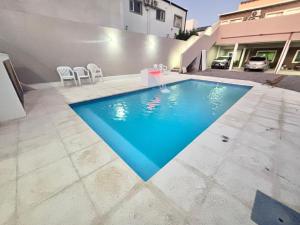 a swimming pool in the middle of a yard with chairs at Sendero Patagonico in Las Grutas