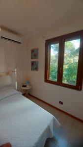 a bedroom with a large bed and two windows at Casa Licia Sorso in Marina di Sorso