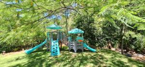 a playground with a slide in the grass at Rio Sereno Suítes Comfort - Lumiar in Lumiar