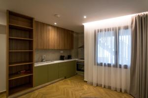 a kitchen with green cabinets and a window and a sink at City Breeze Suites in Heraklio