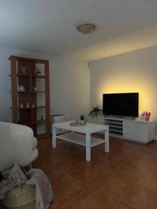 a living room with a television and a white coffee table at Adoria GuestHouse in Adoria