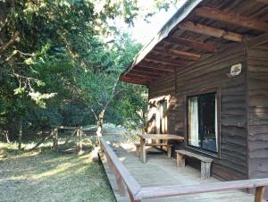 a log cabin with a bench on the porch at Cabañas Río Iculpe in Lago Ranco