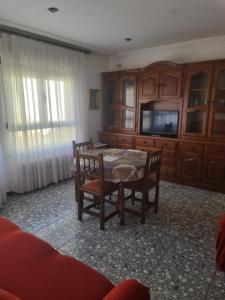 a dining room with a table and chairs and a tv at Dos Hermanas in Sahagún
