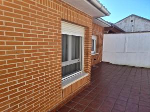 a brick building with a window and a patio at Dos Hermanas in Sahagún