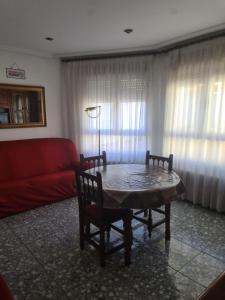 a living room with a table and a red couch at Dos Hermanas in Sahagún +14 photos