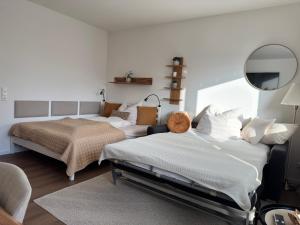 a bedroom with two beds and a mirror at LakeCity Apartment in Klagenfurt