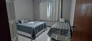 a small bedroom with a bed and a window at loft climatizado em Timóteo próximo à Aperam, Ipatinga e Coronel Fabriciano in Timóteo
