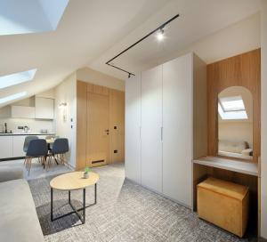 a living room and kitchen with white cabinets and a table at Hotel NOVA Inn Sarajevo in Sarajevo