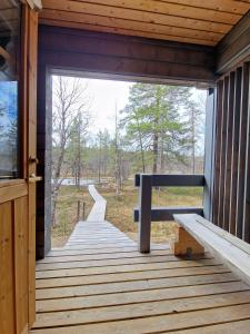a wooden porch of a cabin with a bench on it at Paratiisikuru 2 in Kakslauttanen