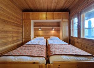 two beds in a room with wooden walls at Paratiisikuru 2 in Kakslauttanen +8 photos