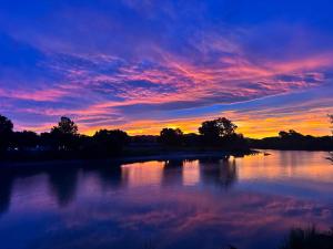 a sunset over a body of water with trees at Rehutai in Wairoa