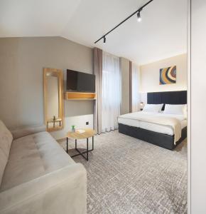 a hotel room with a bed and a couch at Hotel NOVA Inn Sarajevo in Sarajevo