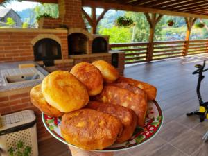 a plate filled with rolls on top of a table at Pensiunea Casa Bradet in Statjunea Borsa