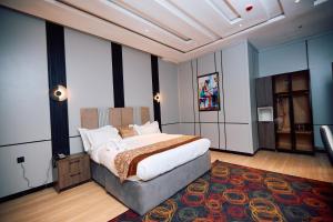 a bedroom with a large bed and a rug at Bourdillon Hotel and apartments in Gwarinpa +19 photos