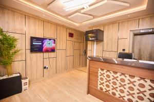 a waiting room with a tv on a wooden wall at Bourdillon Hotel and apartments in Gwarinpa