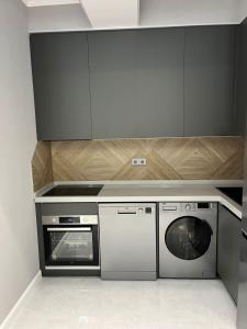 a kitchen with a dishwasher and a washing machine at Qarb Apartment Dernegul metro in Baku