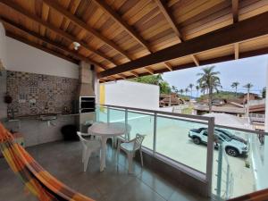 a balcony with a table and chairs and a car at A VER O MAR FLATS in Caraguatatuba