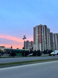 an empty street with tall buildings in a city at Qarb Apartment Dernegul metro in Baku