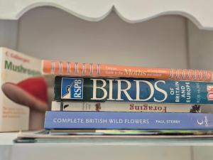 three books stacked on top of each other on a shelf at The Old Mill Shepherds Hut in Okehampton