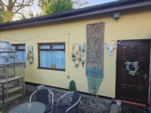 a yellow house with a door and a window at Self contained 1 bedroomed garden flat in Abersychan