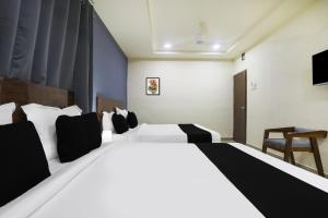 a bedroom with a large white bed and a chair at Townhouse RIO in Hyderabad +26 photos