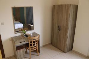 a room with a desk and a mirror and a bed at Mariam Economy Hotel in Aqaba