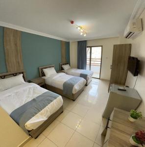 a hotel room with two beds and a television at Mariam Economy Hotel in Aqaba +43 photos