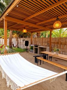 a hammock in a pavilion with a table and benches at Casa Playa "Alicia Micaela" in Zorritos