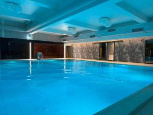 a large swimming pool with blue lighting at Tutu Studio Sinaia cu vedere panoramica Early Checkin in Sinaia
