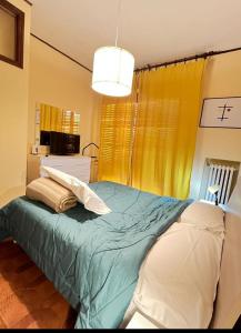 a bedroom with a bed with a green comforter at Home in Arezzo
