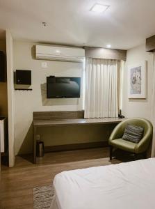 a hotel room with a bed and a television at STOP Mar Suite Privada - NI in Nova Iguaçu