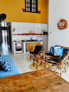 a living room with two chairs and a kitchen at BEACH HOUSE l in Itacaré