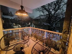 a balcony with two chairs and a pendant light at My Space apartment in Subotica