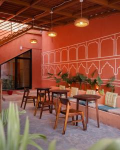 a patio with tables and chairs and a couch at Hammock Hostels - Jaipur in Jaipur