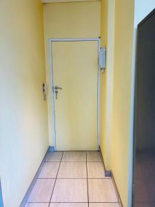 an empty room with a door and a tile floor at Seven Eleven Apartments - Isibaya House in Johannesburg +7 photos