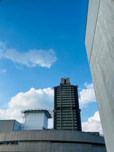 a tall building with a blue sky in the background at Seven Eleven Apartments - Isibaya House in Johannesburg