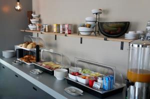 a buffet with plates and bowls of food on a counter at Boutique Hotel & apartments JT Curaçao in Willemstad