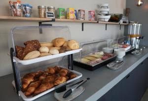 a counter with various types of bread and pastries at Boutique Hotel & apartments JT Curaçao in Willemstad