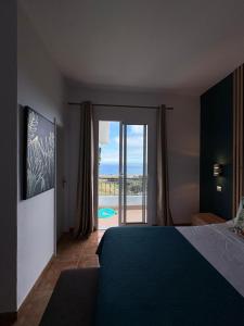 a bedroom with a bed and a view of the ocean at Villa Alta Vista in São Jorge