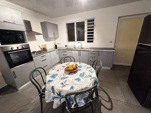 a kitchen with a table with a bowl of fruit on it at Maeva I Papara in Papara +5 photos