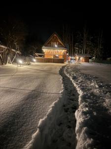 a log cabin in the snow at night at GRABNIK55 in Krasnobród